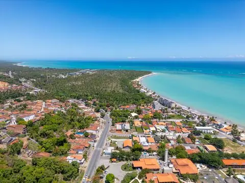 Vista Aérea de Praia em Maceió com Mar Turquesa — Foto aérea de uma praia em Maceió, com mar azul turquesa, coqueiros e casas. Ideal para turismo e verão.
