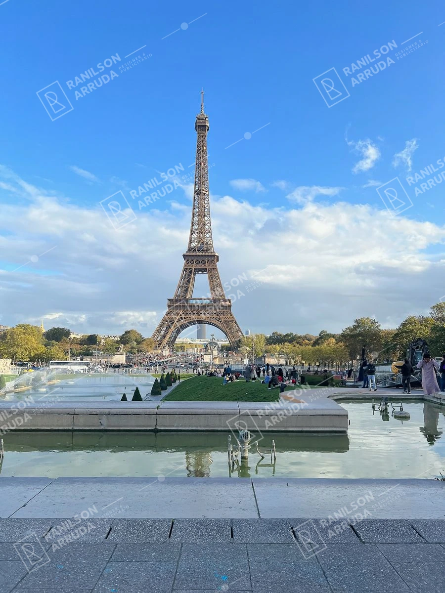 Torre Eiffel em Paris com Fonte e Céu Azul — Foto da Torre Eiffel em Paris, França, com uma fonte e céu azul com nuvens. Ideal para turismo e viagens.
